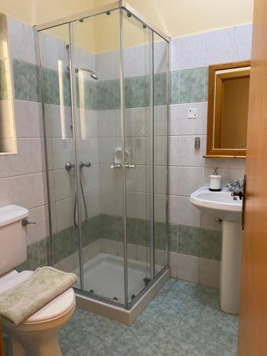 a bathroom with a shower and a toilet and a sink at Gozo Belle Mare Apartments in Marsalforn