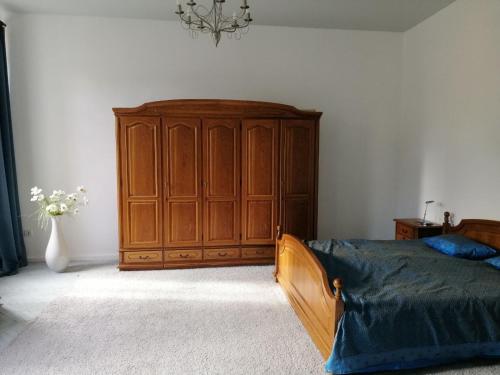 a bedroom with a bed and a wooden cabinet at Затишна квартира в історичному Центрі міста in Chernivtsi