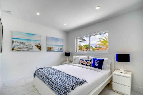 a white bedroom with a bed and two windows at Miami Bliss - Blue Lagoon Haven L18 in Tamiami