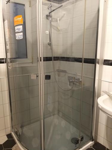 a shower with a glass door in a bathroom at Затишна квартира в історичному Центрі міста in Chernivtsi