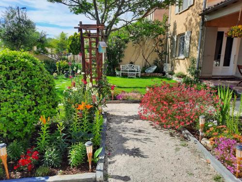 a garden with colorful flowers and a house at La Maison du Chemin des Prairies in Morières-lès-Avignon