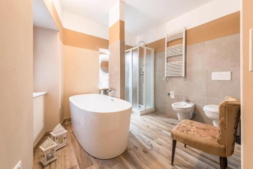 ein Badezimmer mit einer großen Badewanne und einem WC in der Unterkunft Agriturismo Al Gallo Nero Miele in Tenno