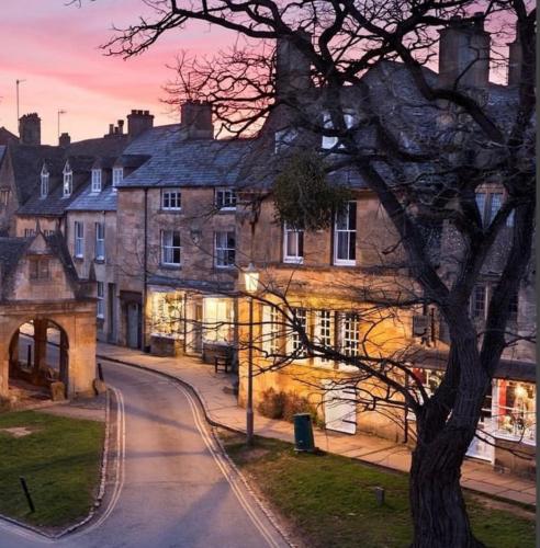 a building with a tree in front of a street at Little Campden House in Chipping Campden