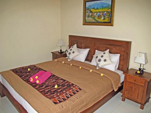 a bedroom with a large bed with pillows at Angga Homestay in Ubud