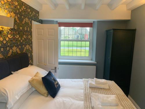 a bedroom with a white bed with a window at The Horseshoe Country Inn in Pickering