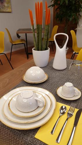 a table with plates and utensils and a vase with carrots at Relais Villa Montedonzelli in Naples