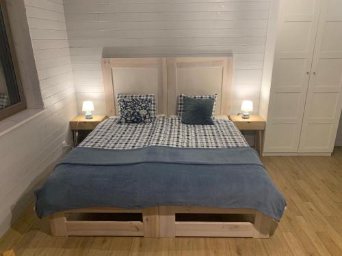 ein Schlafzimmer mit einem großen Bett mit zwei Lampen an Tischen in der Unterkunft Borsk Chochlikowo in Borsk