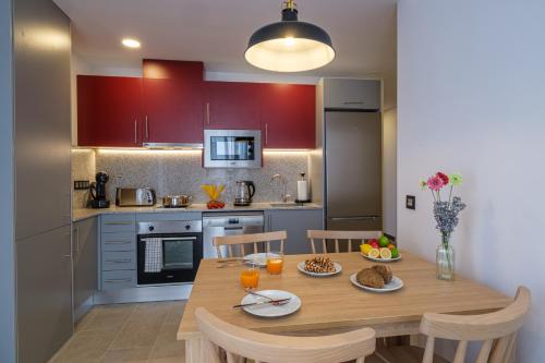 a kitchen with a wooden table and chairs in a kitchen at Tgna Reial 1 in Tarragona