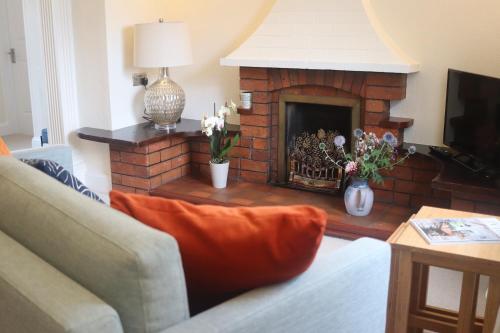 a living room with a brick fireplace with flowers at The Horseshoe Country Inn in Pickering