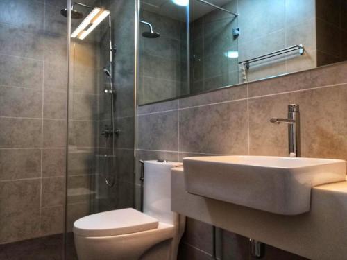 a bathroom with a sink and a toilet and a shower at KL Gateway Premium Residence I HomeBrickz in Kuala Lumpur