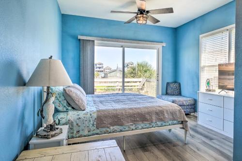 um quarto com paredes azuis, uma cama e uma janela em Spacious North Topsail Family Home with 2 Decks em North Topsail Beach