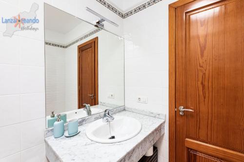 łazienka z umywalką i lustrem w obiekcie Vivienda Vacacional Del Mar w mieście Playa Blanca