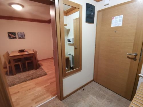 eine Tür, die zu einem Zimmer mit einem Tisch führt in der Unterkunft Apartman 107 - Aparthotel Vučko Jahorina - private host in Jahorina