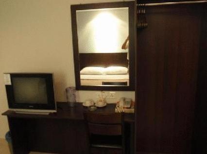 a room with a television and a desk with a mirror at Tiong Nam Hotel in Pasir Gudang