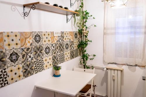 a small kitchen with a white table and tiles on the wall at Little Boho-Chic in Constanţa