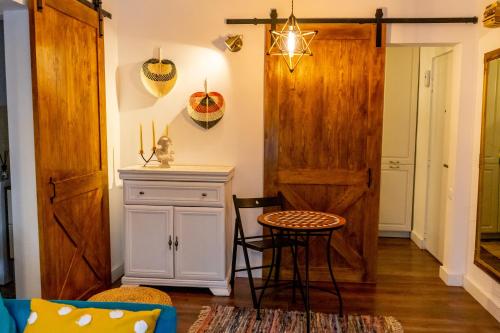 a room with a wooden door and a table and stool at Little Boho-Chic in Constanţa