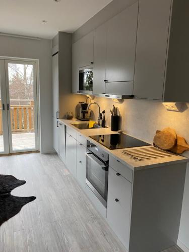 Una cocina con electrodomésticos de acero inoxidable y una gran ventana. en Naturnära boende i vackra Järvsö - F, en Järvsö
