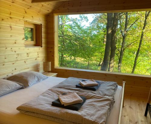 a bed in a log cabin with two towels on it at Kerca Bio Farm in Kercaszomor
