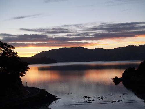 a sunset over a lake with mountains in the background at Captain Eady's Lookout in Portobello