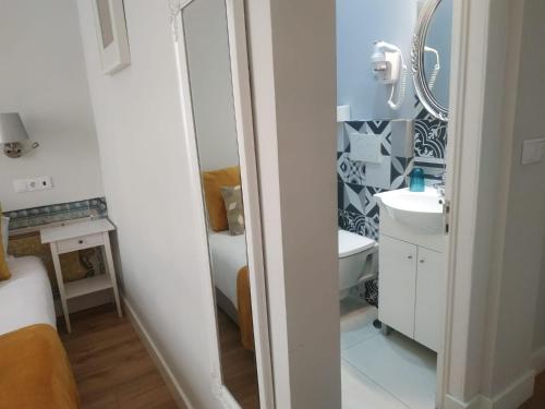a white bathroom with a sink and a mirror at Great Stay Fanqueiros 1 in Lisbon