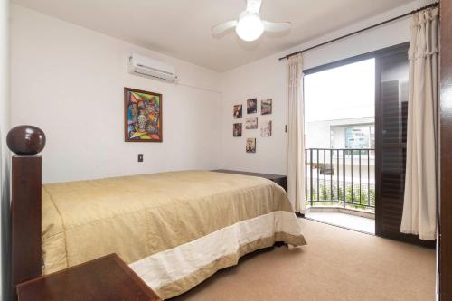 a bedroom with a bed and a balcony at APARTAMENTO BEIRA MAR LATERAL NA PRAIA DE MARISCAL 2661 in Bombinhas