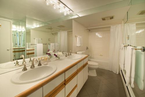 La salle de bains est pourvue de 2 lavabos, de toilettes et d'un miroir. dans l'établissement Standard Two Bedroom - Aspen Alps 101, à Aspen