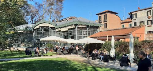 a group of people sitting at tables in front of a building at Bacanal Apartment in Venice