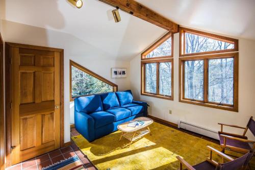 uma sala de estar com um sofá azul e janelas em Lakewood Lodge em Killington