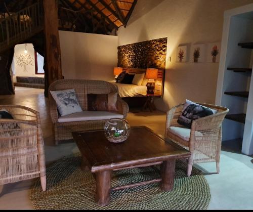 a living room with a table and chairs and a bed at Somkhanda Game Reserve in Pongola