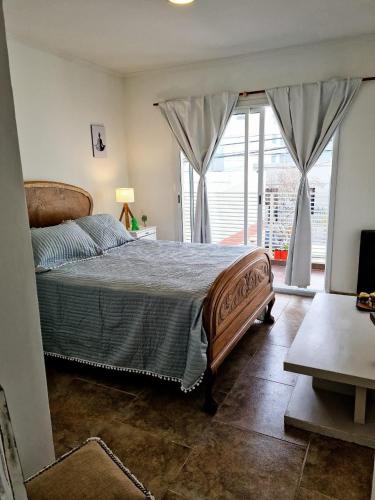 een slaapkamer met een bed en een groot raam bij Apart 14 de Julio in Tandil