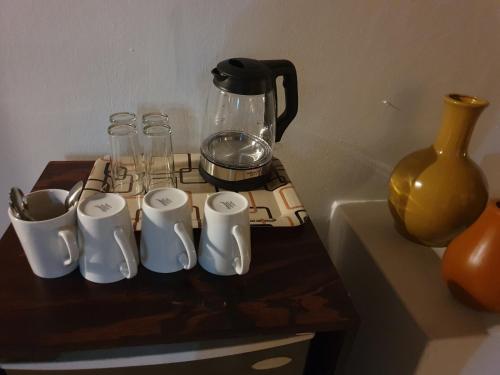 a table with cups and a blender and a vase at Somkhanda Game Reserve in Pongola