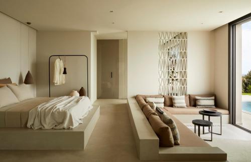 a bedroom with a bed and a couch at Villa Dione Kefalonian Chic Villas in Spartia