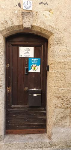 a wooden door in a stone building with a sign on it at Joshroom in Caux
