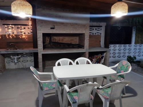 stół i krzesła w pokoju z kominkiem w obiekcie CASA CUCHILLA ALTA w mieście Cuchilla Alta
