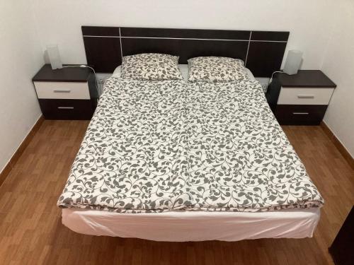 uma cama com um edredão preto e branco e duas mesas de cabeceira em Apartamento RETECH em Las Palmas de Gran Canaria