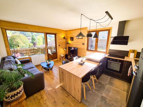 un salon avec un canapé et une table dans l'établissement Appt Tournette - Centre Village, Vue Montagne - AravisTour, à Saint-Jean-de-Sixt