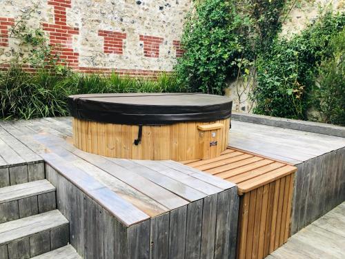 une baignoire en bois installée au-dessus d'une terrasse en bois dans l'établissement Maison d'architecte en plein cœur d'Honfleur avec bain nordique, à Honfleur