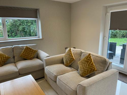 ein Wohnzimmer mit 2 Sofas und einem Tisch in der Unterkunft Lux Cottage in Blackburn