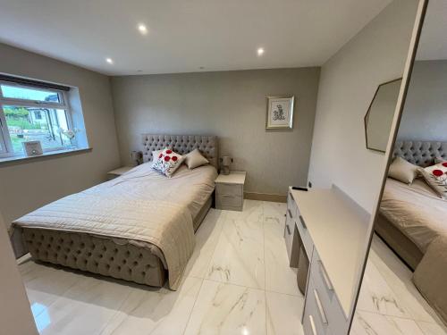 a bedroom with a bed and a mirror at Lux Cottage in Blackburn