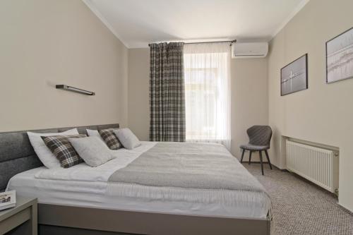 a bedroom with a large bed and a chair at Deribas Hotel in Odesa