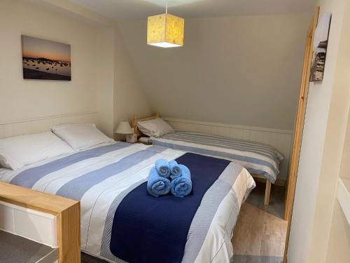 a bedroom with two beds with blue towels on the bed at Appletree in Hugh Town