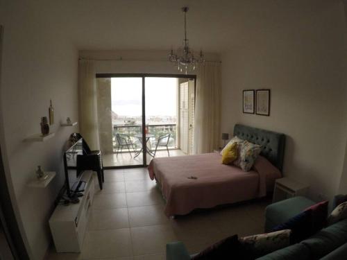 een slaapkamer met een bed en uitzicht op een balkon bij Rental unit in RAHA village compound, special view in Aqaba