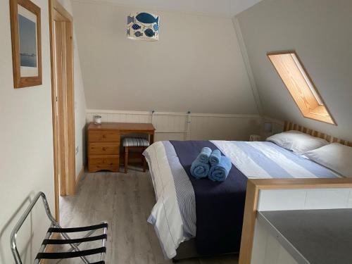 a bedroom with a bed with blue towels on it at Appletree in Hugh Town