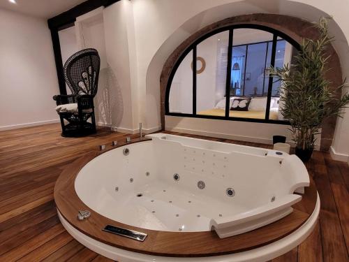 a large bath tub in a room with a large window at Jacuzzi des Tanneurs in Ribeauvillé