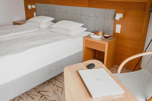 a bedroom with a bed with a laptop on a table at Hotel Marina Club in Olsztyn