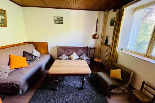 ein Wohnzimmer mit einem Sofa und einem Tisch in der Unterkunft Nice Chalet With View On The Mountain in La Salle Les Alpes