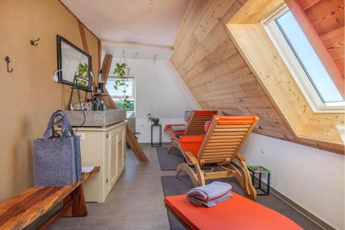 a living room with orange chairs and a sink at Apartments im Ferienhaus zum alten Spital in Dornstetten