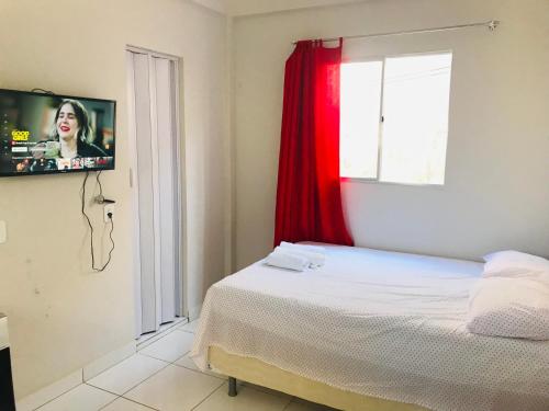 a bedroom with a bed and a tv on a window at Aconchego em Parnaíba JW. 2 in Parnaíba