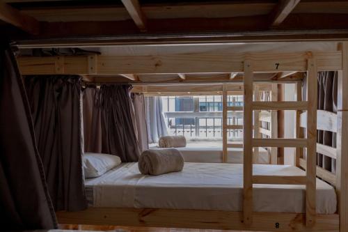 a wooden bunk bed in a room with a window at HOSTEL CUARTO in Sao Paulo