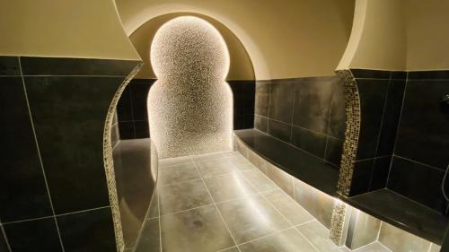 La salle de bains est pourvue d'une douche à l'italienne et d'un mur en pierre. dans l'établissement Coin Aubrac Pôle Détente, à Chaudes-Aigues